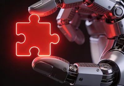 Robotic hand holding a red puzzle piece representing advanced add on for coding